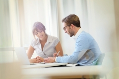 Colleagues working in modern office with laptop